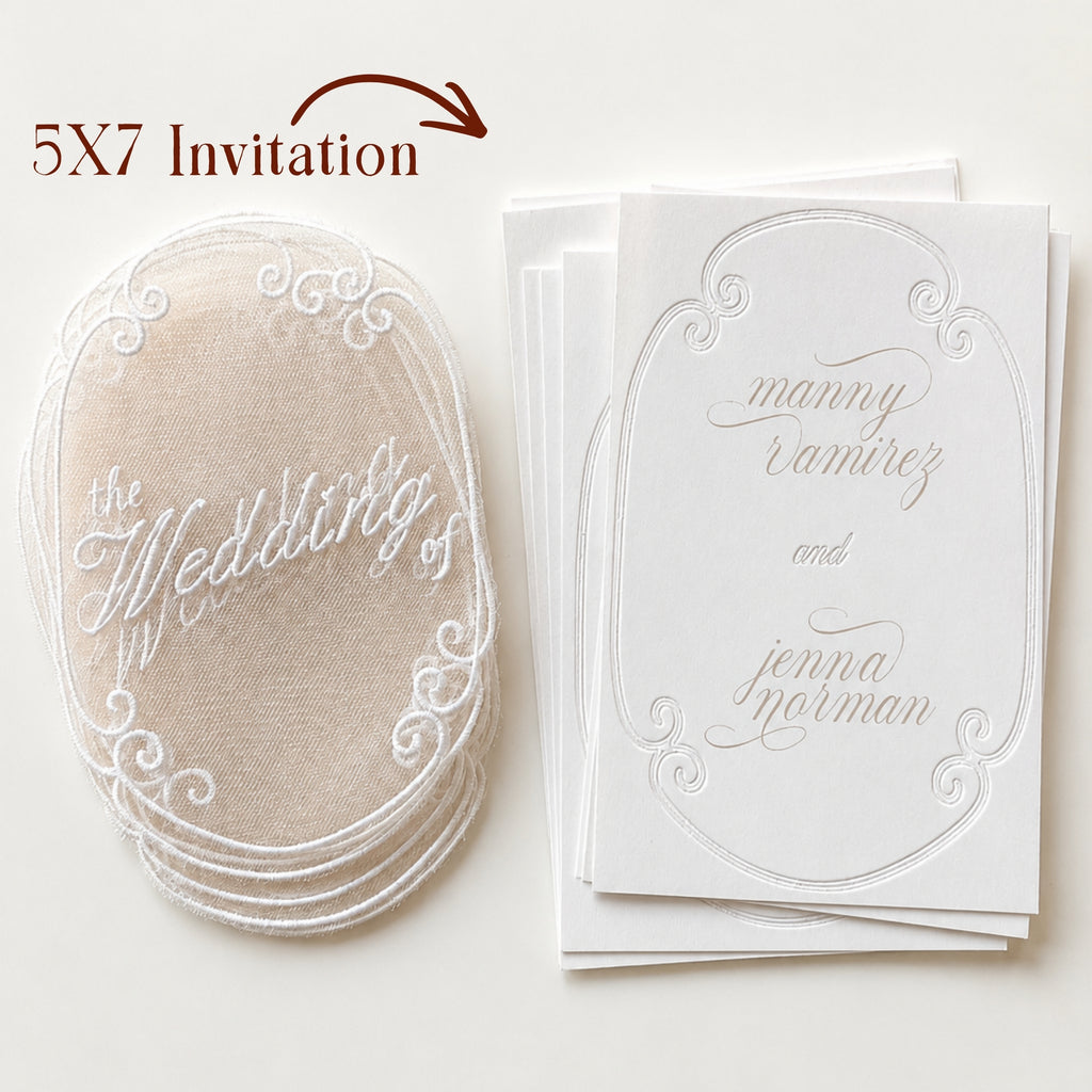 Close-up of translucent embroidered wedding invitation overlay showing white thread lettering, delicate mesh, and ornate embroidery.
