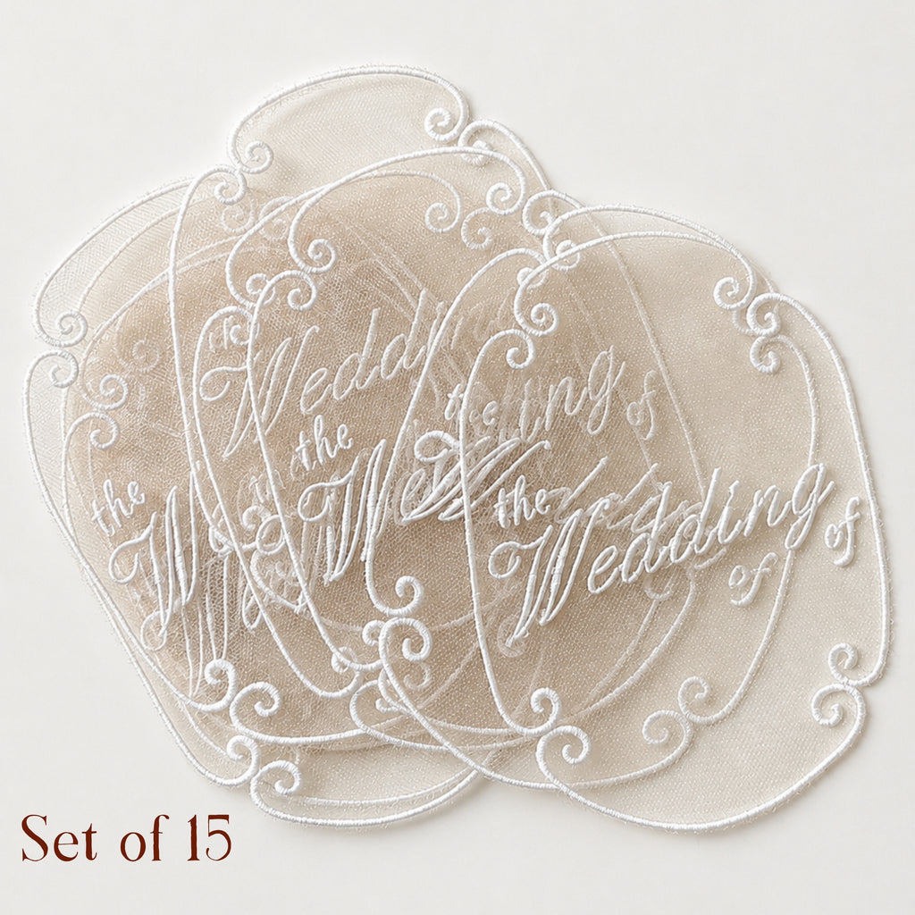 Handmade sheer embroidered wedding invitation topper with white script and vintage-inspired scroll border detailing.